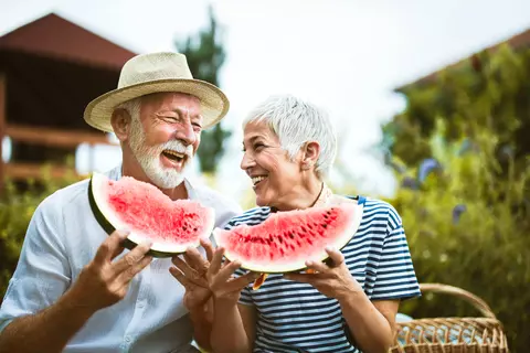 Man en vrouw die watermeloen eten
