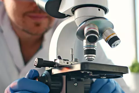 Man kijkt door microscoop