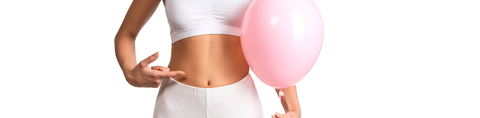 Vrouw in sportoutfit heeft ballon vast en wijst naar haar buik